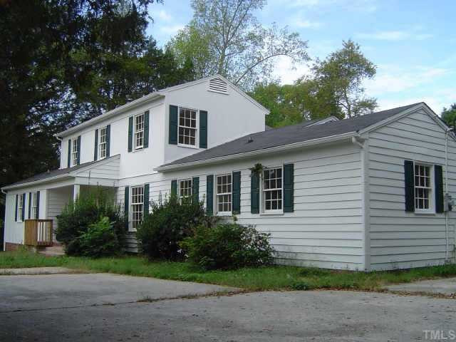 119 King William Road Raleigh, NC 27610 - Photo 6 of 7 a white house with a small yard plants and large trees