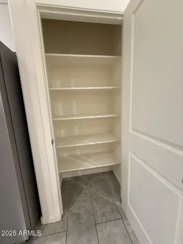 a view of walk in closet with empty racks