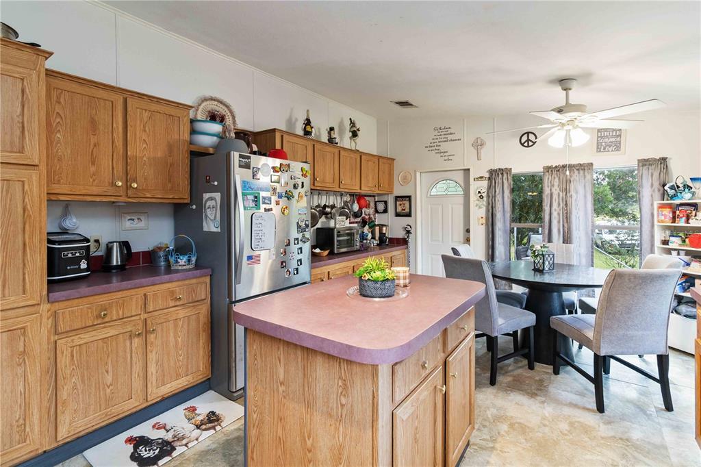 6701 Nova Road St. Cloud, FL 34771 - Photo 12 of 49 a kitchen with a refrigerator a stove a sink dishwasher and white cabinets with wooden floor