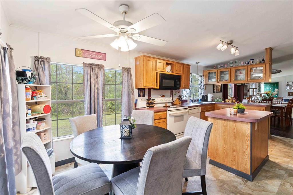 6701 Nova Road St. Cloud, FL 34771 - Photo 13 of 49 a dining room with furniture a rug a flat screen tv and a large window