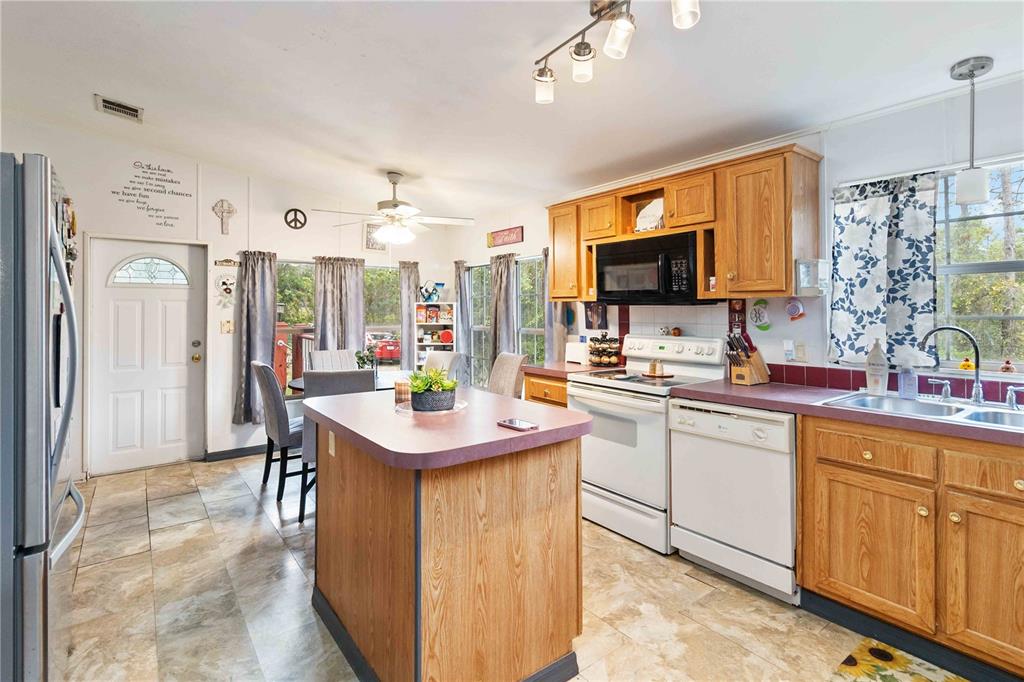 6701 Nova Road St. Cloud, FL 34771 - Photo 9 of 49 a kitchen with stainless steel appliances kitchen island granite countertop a sink and cabinets