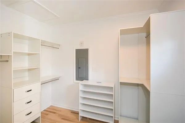 an empty room with wooden floor ceiling fan and windows