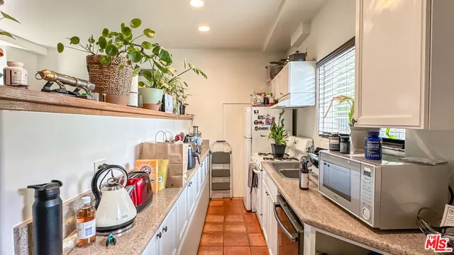 a kitchen with stainless steel appliances granite countertop a stove a sink dishwasher and cabinets with wooden floor