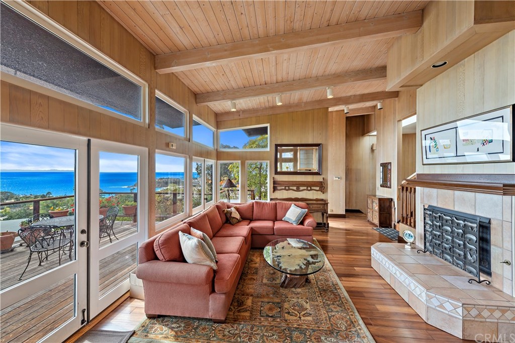 1560 Sunset Ridge Drive Laguna Beach, CA 92651 - Photo 1 of 1 a living room with furniture a fireplace and a floor to ceiling window