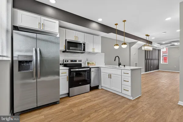 a kitchen with stainless steel appliances kitchen island granite countertop a refrigerator oven a sink and dishwasher