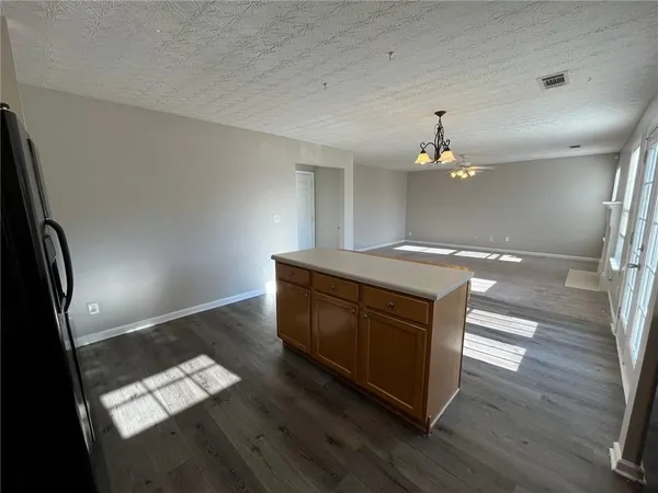 a kitchen with granite countertop white cabinets and wooden floor