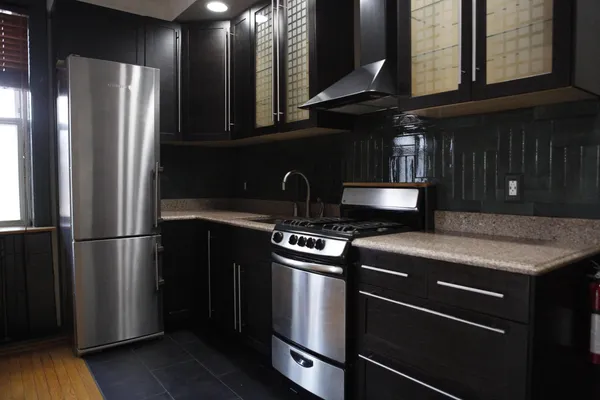 a kitchen with metallic refrigerator and a sink