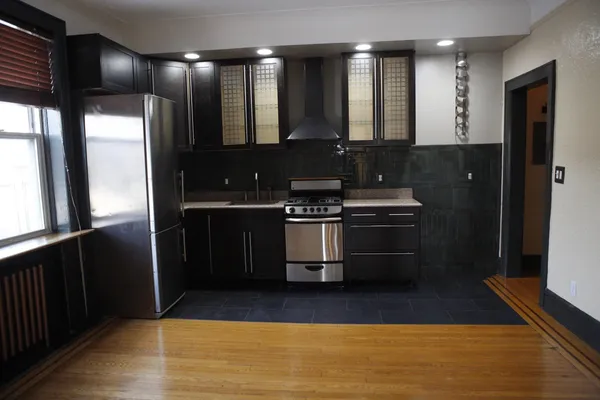 a kitchen with stainless steel appliances granite countertop a stove a refrigerator and a sink