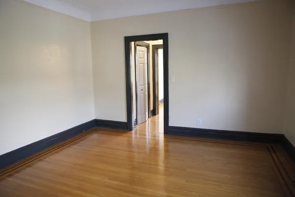 a view of an empty room and wooden floor