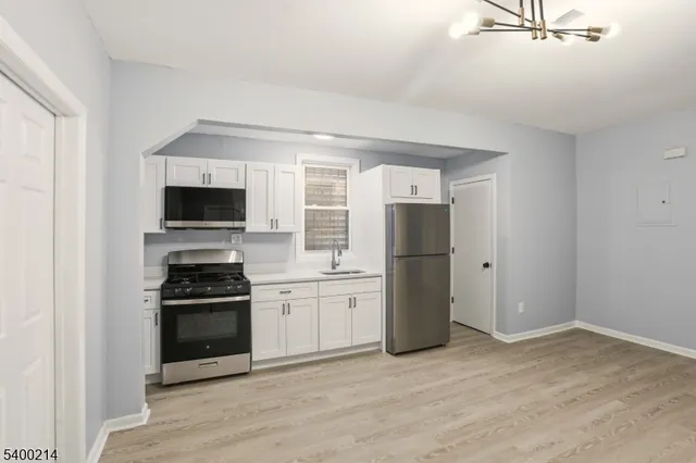 an empty room with wooden floor and ceiling fan