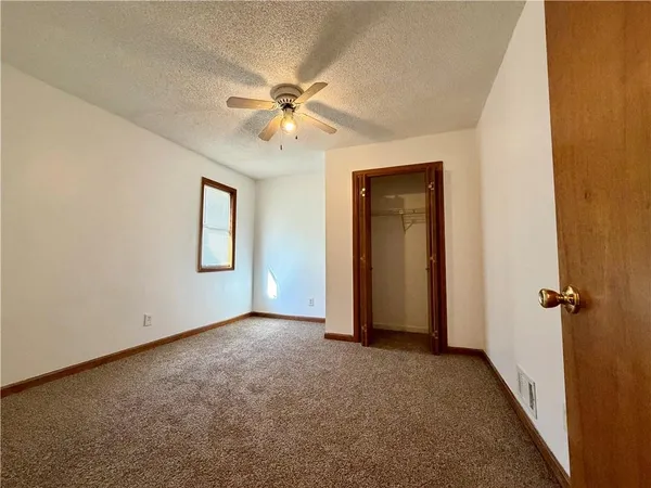 an empty room with windows and closet