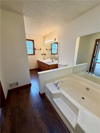 a spacious bathroom with a bathtub and a sink