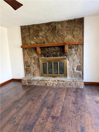 a view of empty room with wooden floor and fireplace