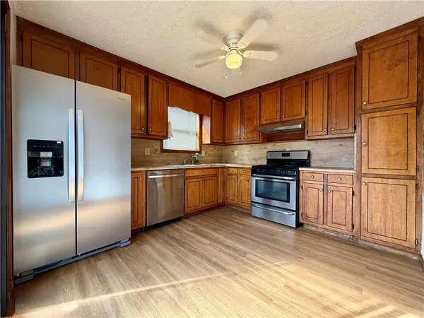 a kitchen with granite countertop stainless steel appliances a refrigerator sink and microwave