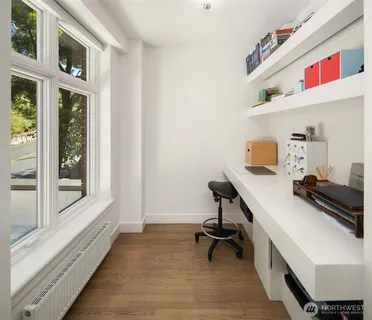 a bedroom with a bed and large windows