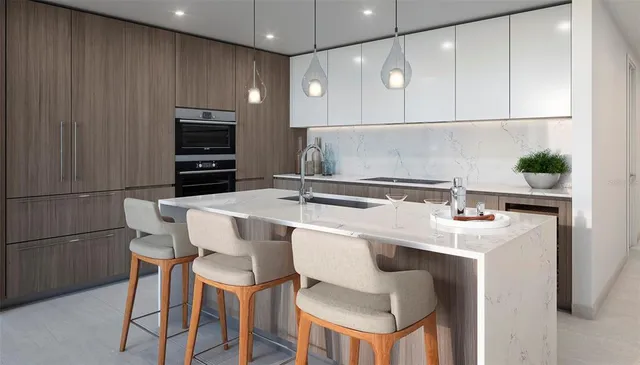 a kitchen with a sink and chairs