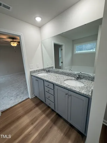 a bathroom with a granite countertop sink and a mirror