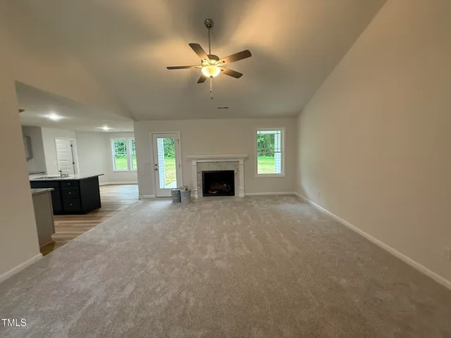 a view of an empty room with a fireplace and a window
