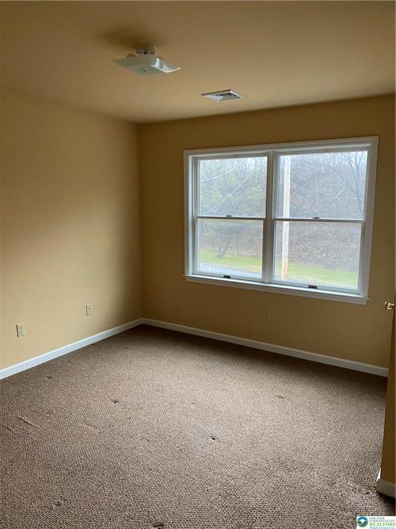 2862 Christian Springs Road Nazareth, PA 18064 - Photo 10 of 16 A well-lit bedroom with carpeting offers a serene view of the surrounding trees.