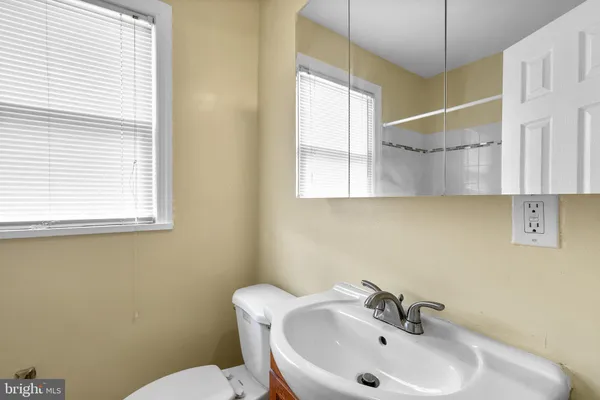 a bathroom with a sink mirror and toilet