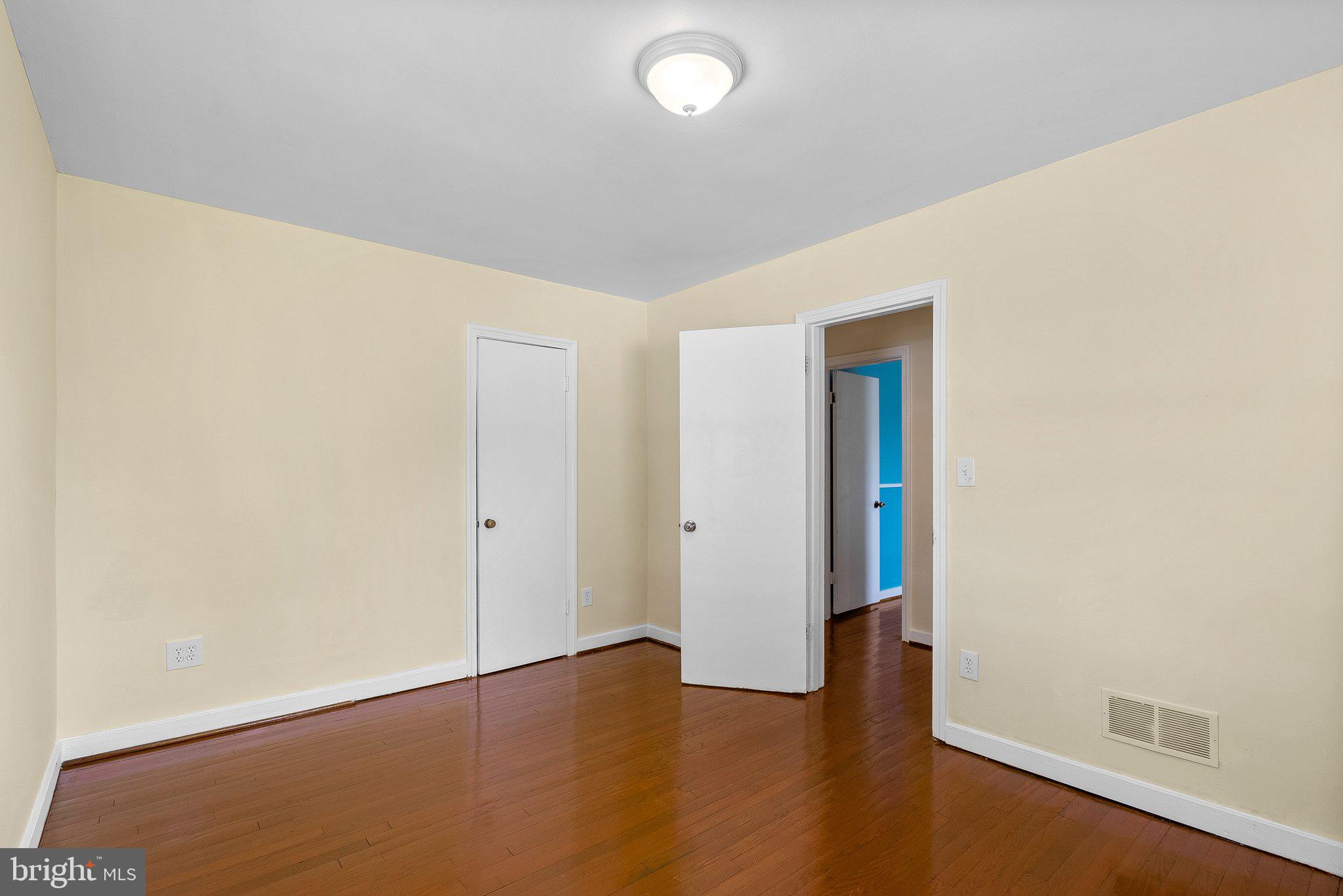 10112 Sutherland Road Silver Spring, MD 20901 - Photo 14 of 29 an empty room with wooden floor and windows