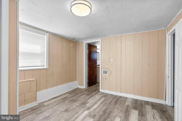 a view of an empty room with closet and a window