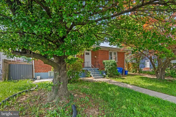 front view of a house with a yard and an trees