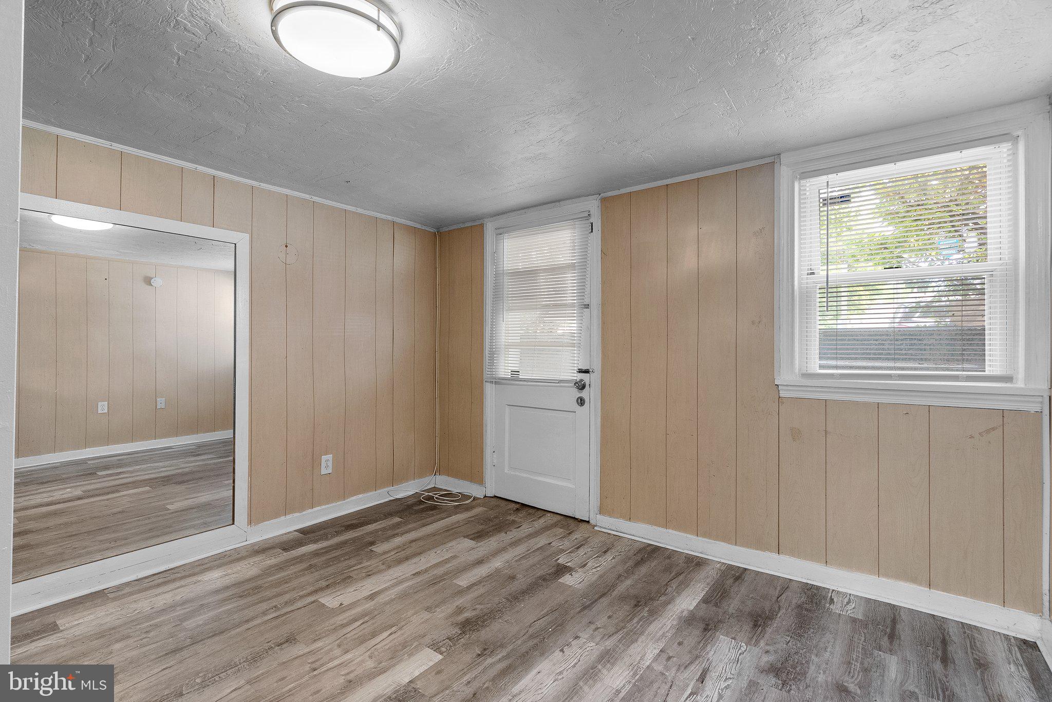 10112 Sutherland Road Silver Spring, MD 20901 - Photo 23 of 29 a view of an empty room with wooden floor and window