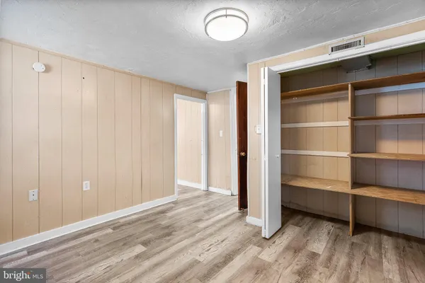 a view of a room with walk in closet and wooden floor