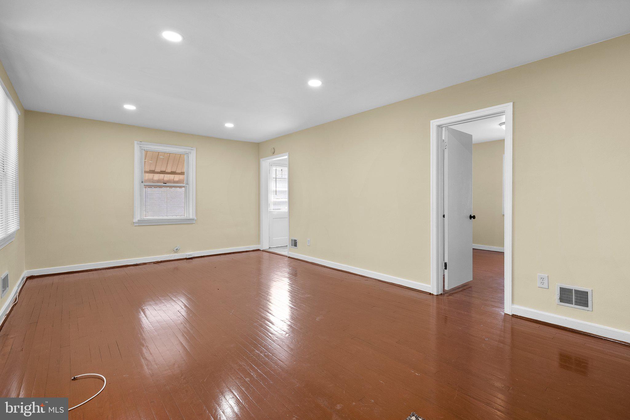 10112 Sutherland Road Silver Spring, MD 20901 - Photo 4 of 29 an empty room with wooden floor and windows