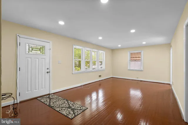 an empty room with windows and hardwood floor