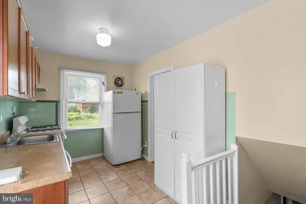 a kitchen with a refrigerator and a stove top oven