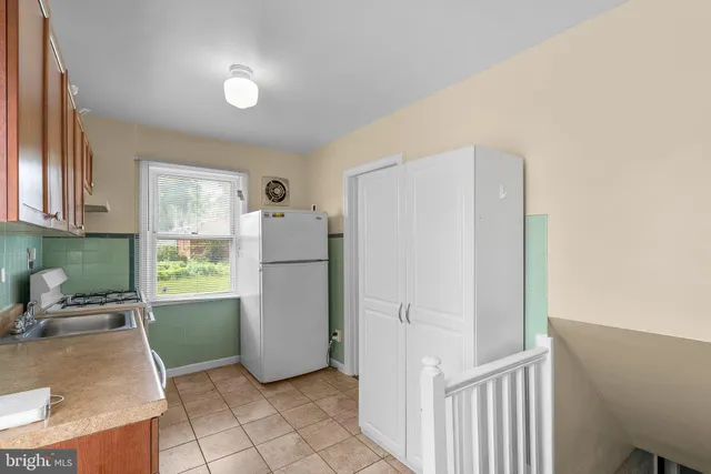 a kitchen with a refrigerator and a stove top oven