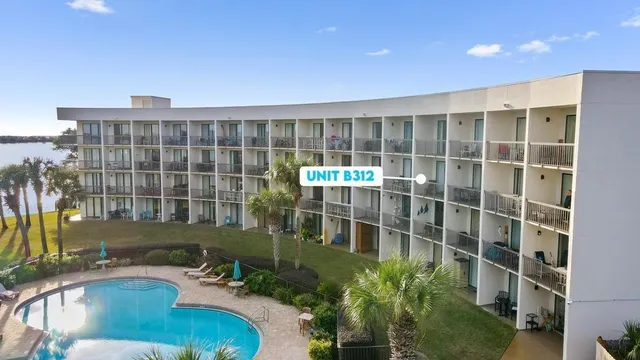 a view of a house with a floor to ceiling window and wooden fence