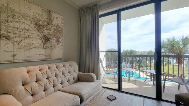 a blue couch sitting in front of a window with floor to ceiling window