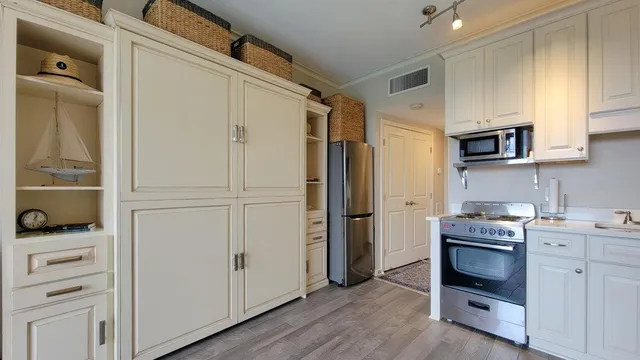a kitchen with a refrigerator stove and white cabinets