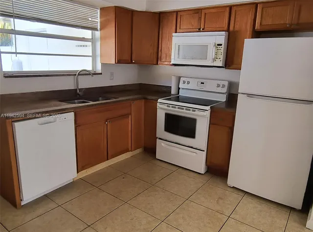 a kitchen with granite countertop a sink a stove and cabinets