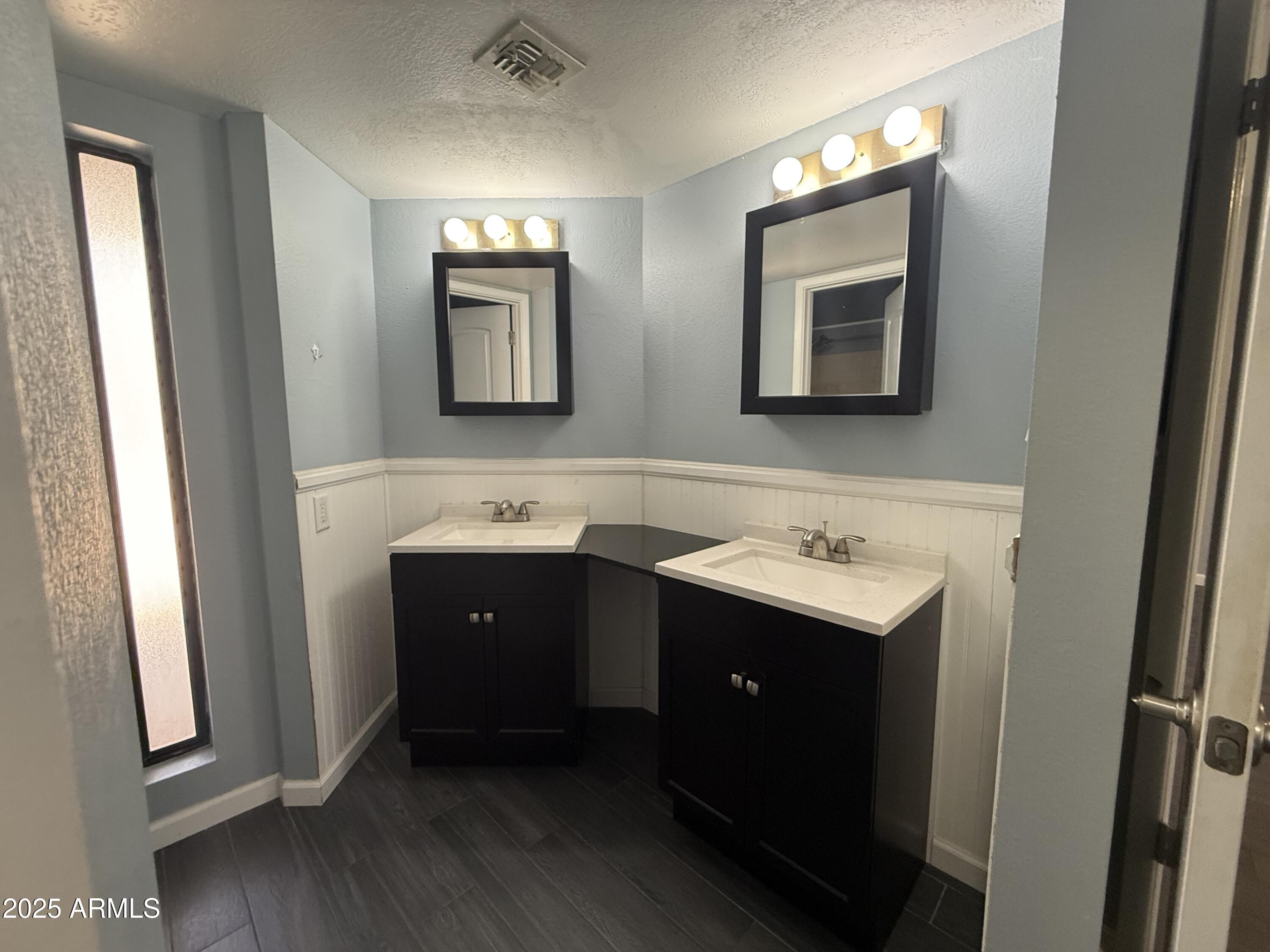 11666 North 28th Drive, Unit 155 Phoenix, AZ 85029 - Photo 11 of 28 a bathroom with a double vanity sink and mirror