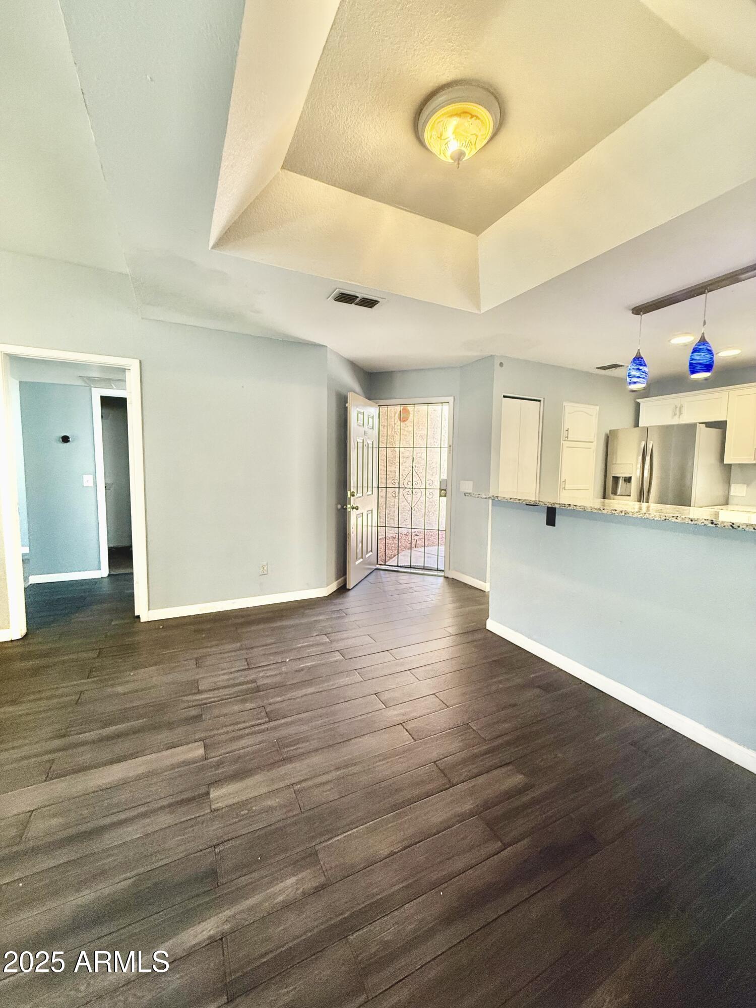 11666 North 28th Drive, Unit 155 Phoenix, AZ 85029 - Photo 5 of 28 a view of an empty room with wooden floor and a window
