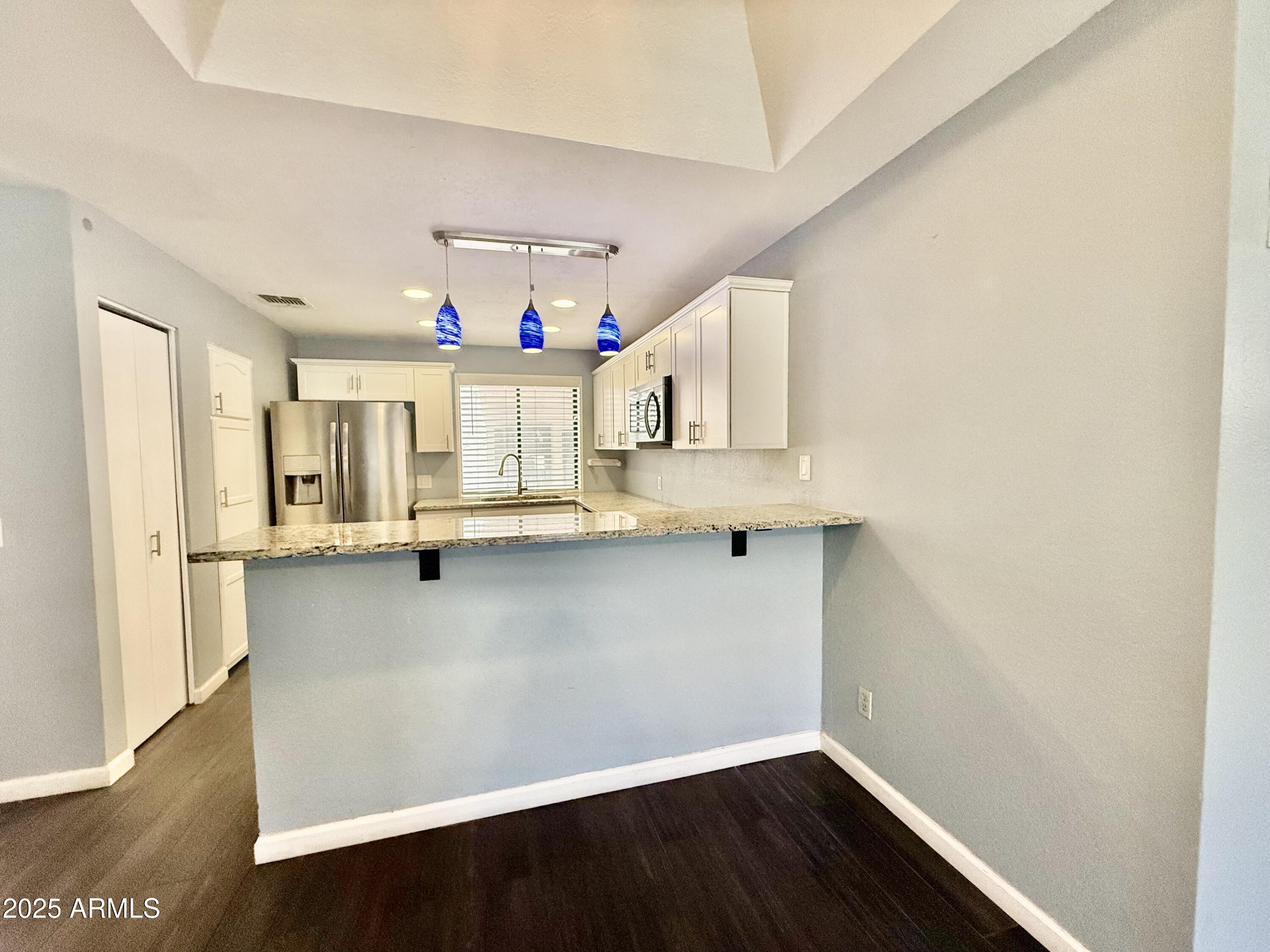11666 North 28th Drive, Unit 155 Phoenix, AZ 85029 - Photo 7 of 28 a view of cabinets and wooden floor