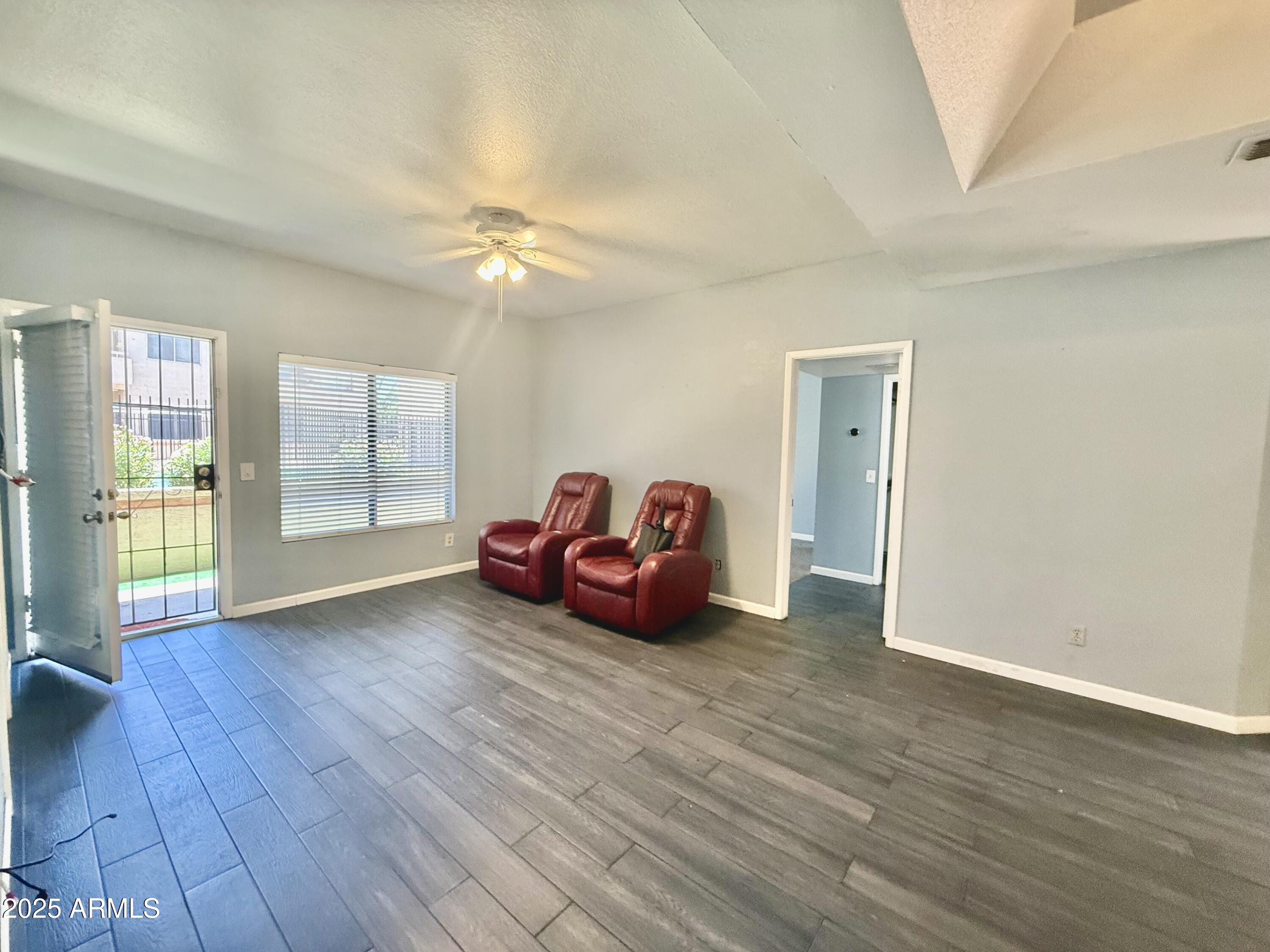11666 North 28th Drive, Unit 155 Phoenix, AZ 85029 - Photo 9 of 28 an empty room with wooden floor and windows