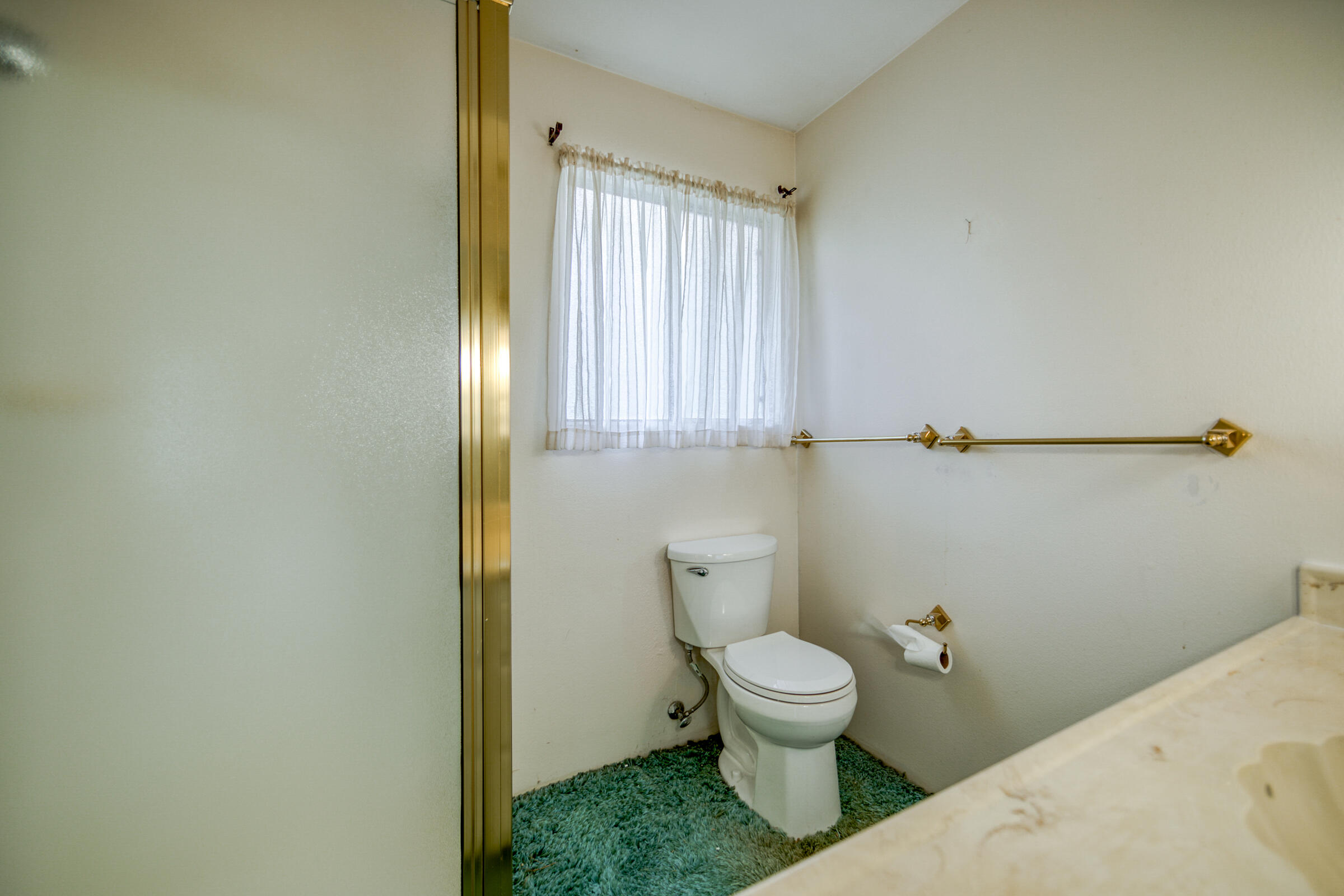 8442 Ranchette Drive Redding, CA 96001 - Photo 22 of 26 a white toilet sitting next to a bathroom sink and vanity
