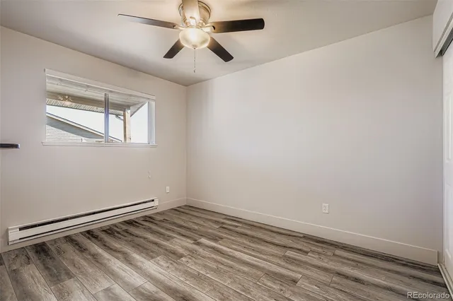 an empty room with a window and a ceiling fan