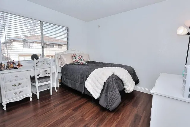 a bedroom with a bed and closet with wooden floor