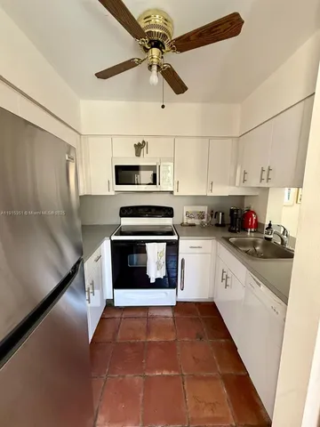 a kitchen with granite countertop a refrigerator and a stove top oven