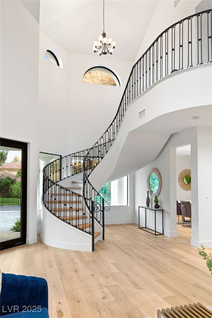 2316 Prometheus Court Henderson, NV 89074 - Photo 44 of 92 Foyer entrance featuring visible vents, high vaulted ceiling, a chandelier, and stairs