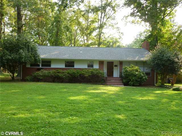 a front view of a house with a yard and trees