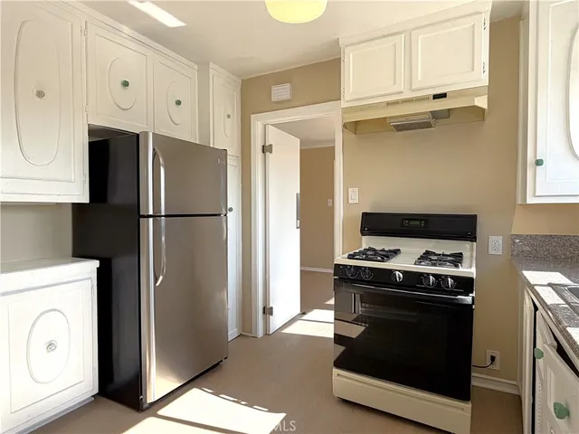 a kitchen with stainless steel appliances a refrigerator a stove a sink and a cabinets