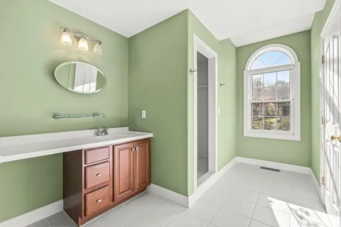 a spacious bathroom with a mirror a sink and a mirror