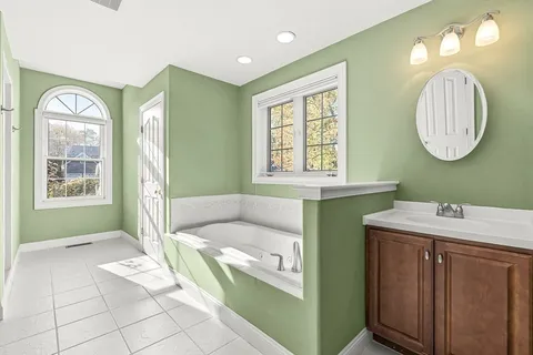 a bathroom with a bathtub sink and mirror